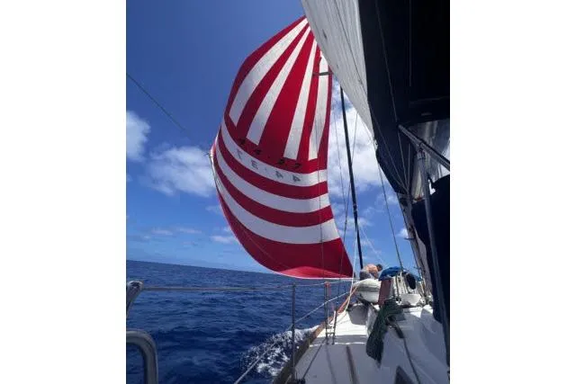 Unicorn Yacht Photos Pics Sailing on a 1988 Hylas Custom 44 with red and white spinnaker in open ocean.