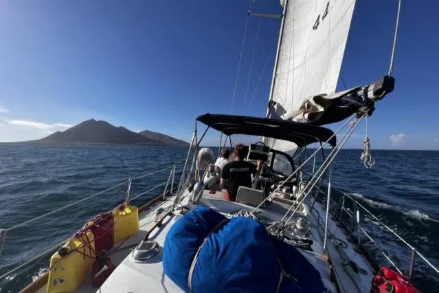 Unicorn Yacht Photos Pics Sailing on 1988 Hylas Custom 44 yacht with island view and clear blue sky.