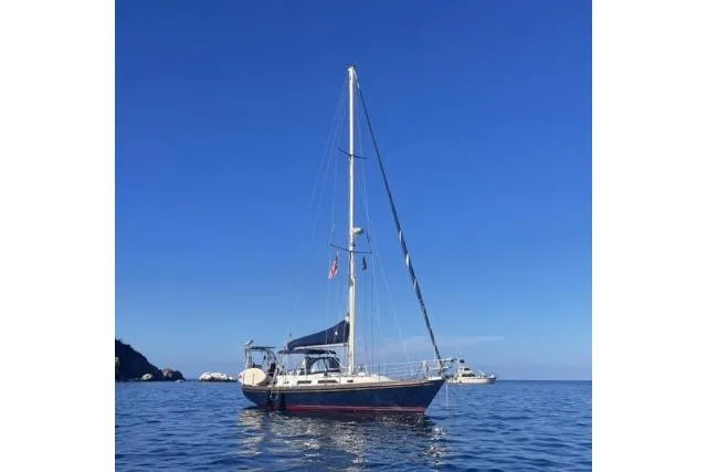 Unicorn Yacht Photos Pics Sailboat on calm sea, Hylas Custom 44, 1988 model, under clear blue sky.
