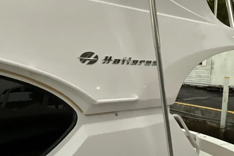 Temptation Yacht Photos Pics 2008 Hatteras 77 Convertible yacht, sleek white exterior with logo detail.