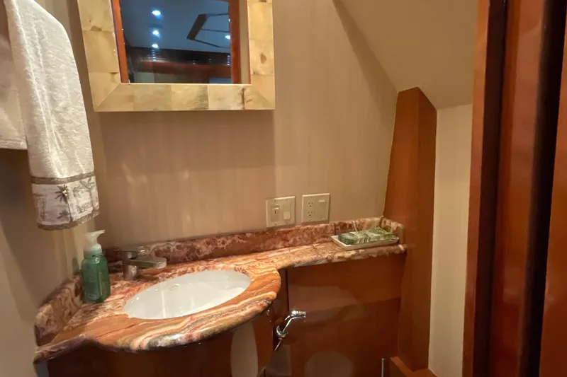 Temptation Yacht Photos Pics Luxurious bathroom in 2008 Hatteras 77 Convertible yacht with marble countertop and wooden accents.