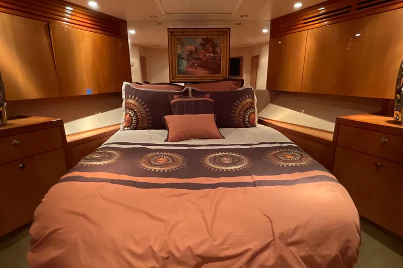 Temptation Yacht Photos Pics Luxurious bedroom interior of 2008 Hatteras 77 Convertible yacht with elegant bedding and wood cabinetry.