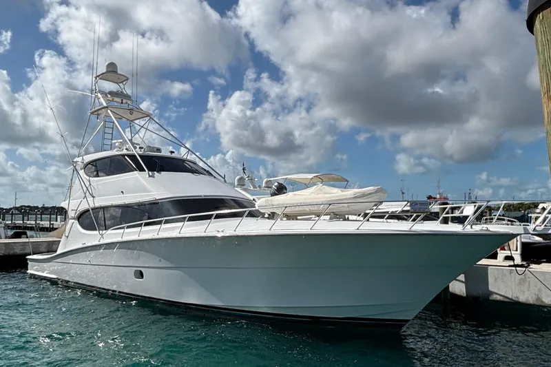 Temptation Yacht Photos Pics 2008 Hatteras 77 Convertible yacht docked under a cloudy sky.
