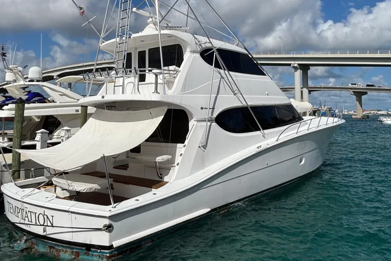 Temptation Yacht Photos Pics 2008 Hatteras 77 Convertible yacht docked in marina, featuring sleek design and spacious deck.