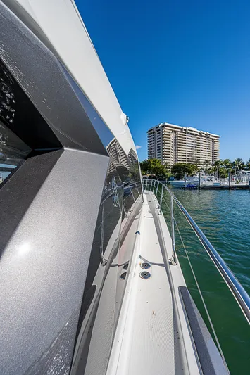 Beygu002f122 Yacht Photos Pics Beneteau Gran Turismo 45 yacht, 2022 model, cruising near a marina with a cityscape backdrop.