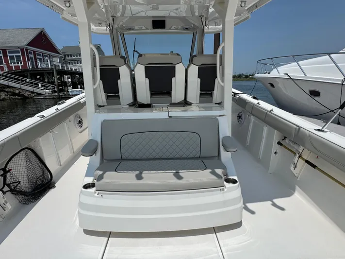  Yacht Photos Pics 2022 Pursuit S 378 Sport boat interior with seating and dockside view.