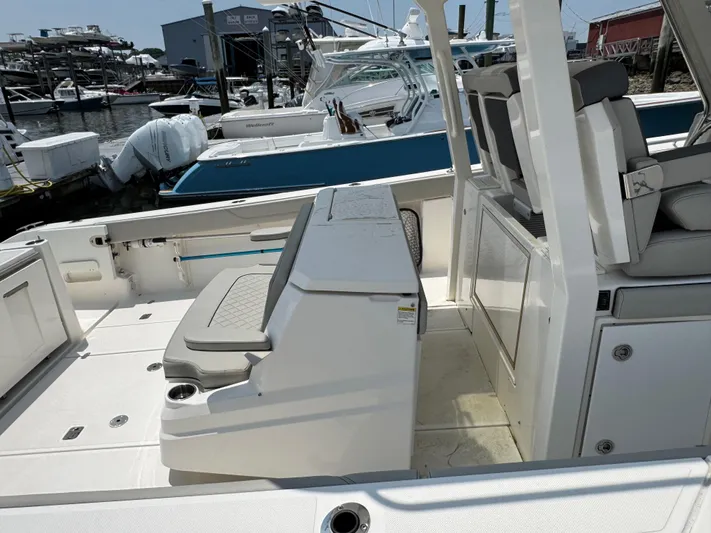  Yacht Photos Pics 2022 Pursuit S 378 Sport boat interior with seating and storage, docked at a marina.