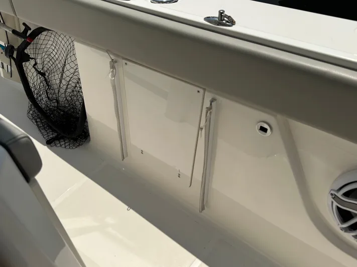  Yacht Photos Pics 2022 Pursuit S 378 Sport boat interior with fishing net and storage compartment.