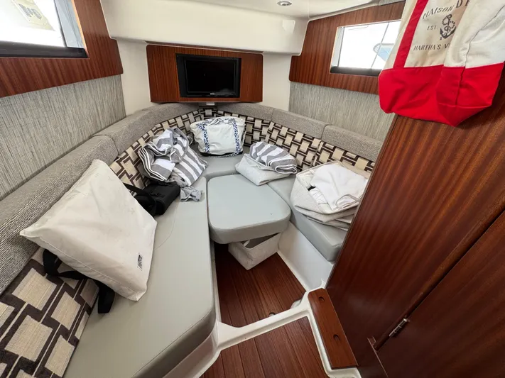  Yacht Photos Pics 2022 Pursuit S 378 Sport cabin interior with cozy seating and nautical decor.