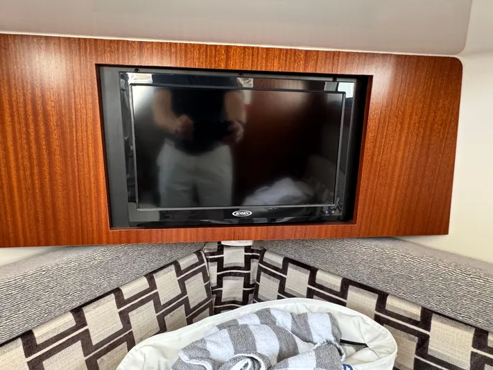  Yacht Photos Pics 2022 Pursuit S 378 Sport interior with TV, wood paneling, and patterned seating.