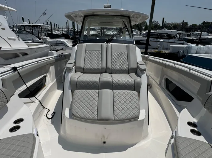  Yacht Photos Pics 2022 Pursuit S 378 Sport boat with luxurious seating in a marina setting.