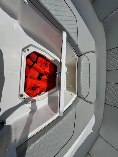  Yacht Photos Pics 2022 Pursuit S 378 Sport boat with open storage compartment containing life jackets.