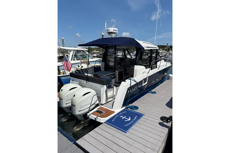  Yacht Photos Pics 2020 Jeanneau NC 895 boat docked with twin Yamaha engines, blue canopy, and American flag.