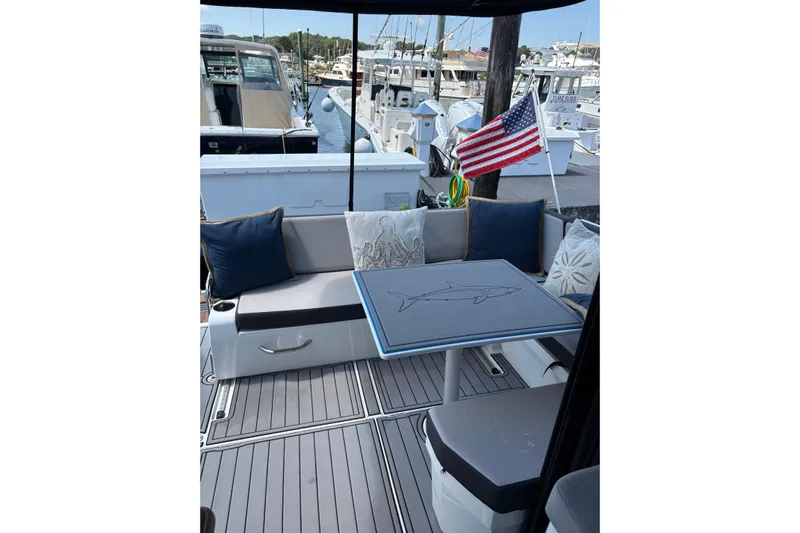  Yacht Photos Pics Cozy seating area on 2020 Jeanneau NC 895 boat with American flag and nautical decor.