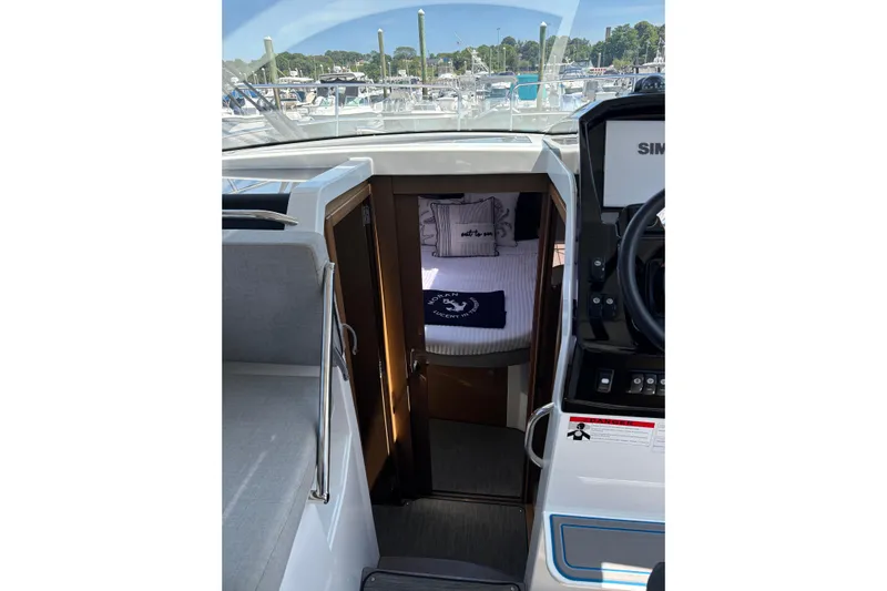  Yacht Photos Pics 2020 Jeanneau NC 895 cabin interior with cozy bedding and helm view.
