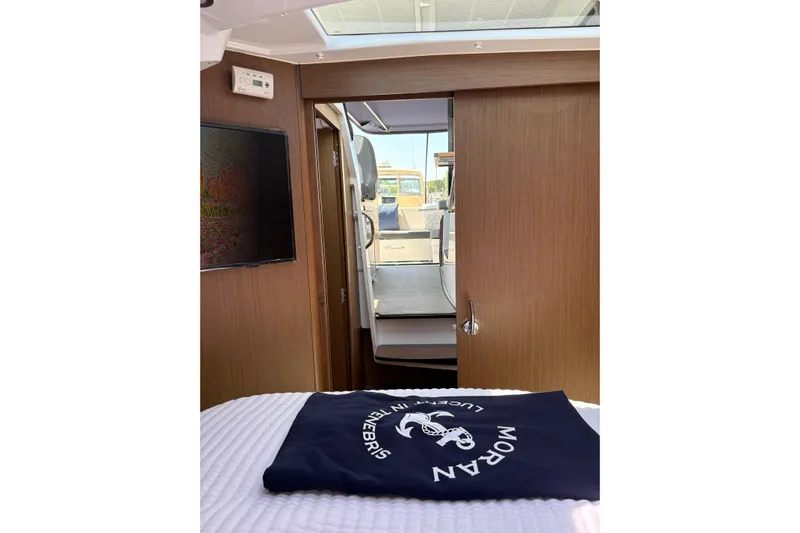  Yacht Photos Pics Interior view of 2020 Jeanneau NC 895 boat cabin with wooden finish and open door.