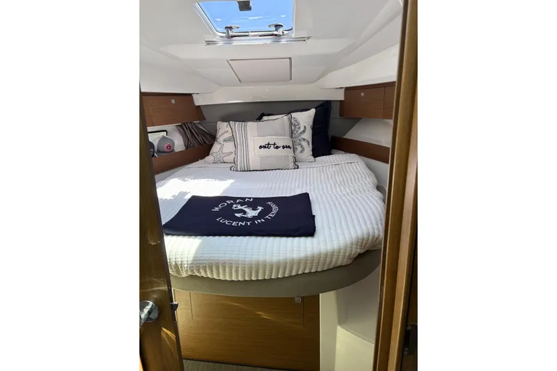  Yacht Photos Pics Cozy cabin interior of 2020 Jeanneau NC 895 with bed and nautical decor.