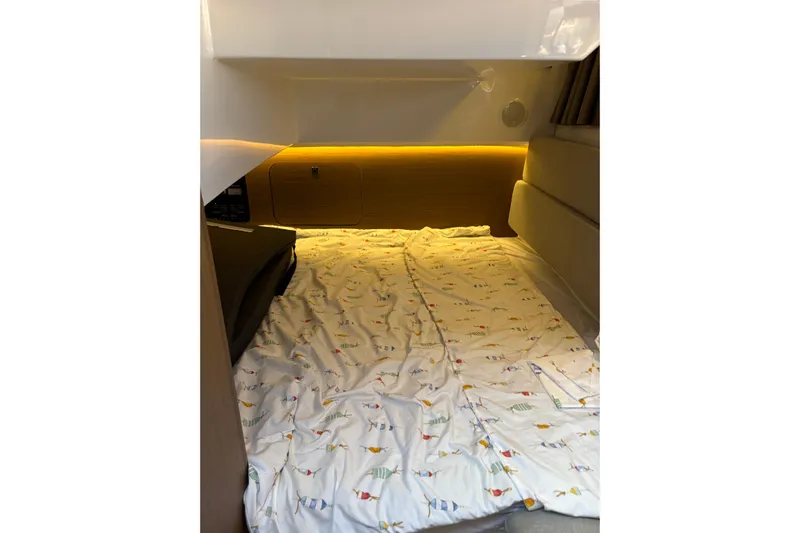  Yacht Photos Pics 2020 Jeanneau NC 895 cabin interior with cozy bedding and ambient lighting.