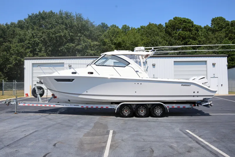  Yacht Photos Pics 2021 Pursuit OS 325 Offshore boat on trailer, parked outdoors near storage facility.