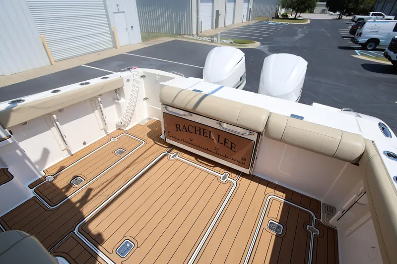  Yacht Photos Pics 2021 Pursuit OS 325 Offshore boat with teak deck and dual engines in a parking lot.