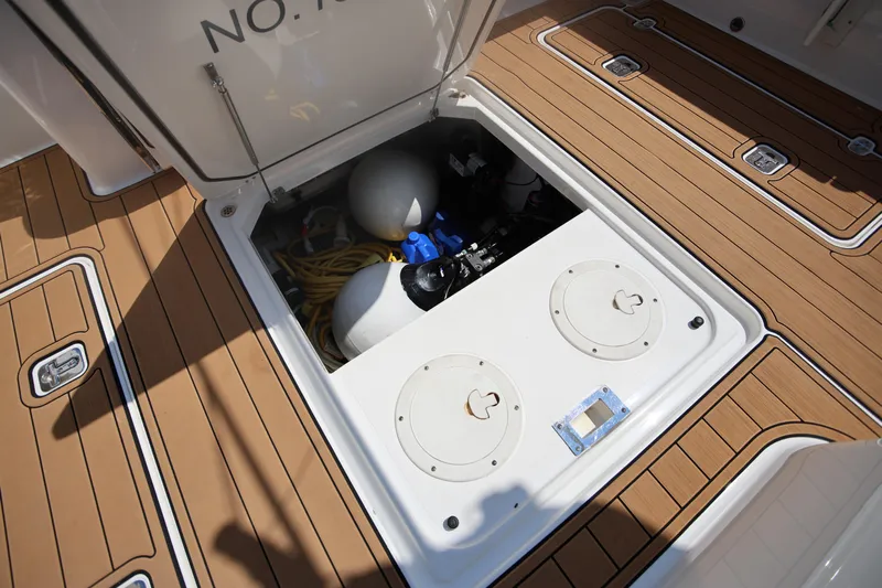  Yacht Photos Pics 2021 Pursuit OS 325 Offshore boat storage compartment with equipment and accessories.