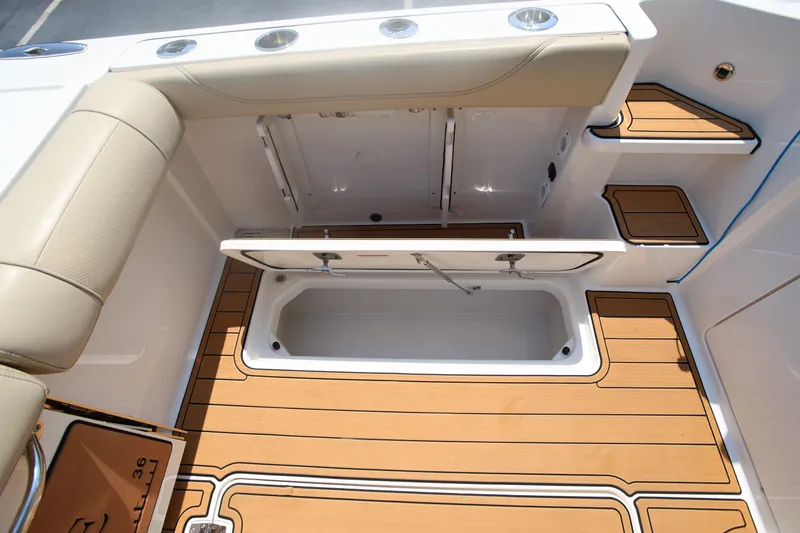  Yacht Photos Pics 2021 Pursuit OS 325 Offshore boat interior with open storage compartment and teak flooring.