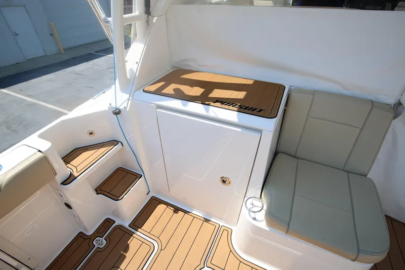  Yacht Photos Pics 2021 Pursuit OS 325 Offshore boat interior with cushioned seating and teak flooring.