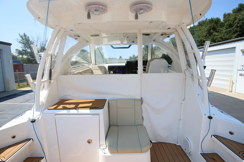  Yacht Photos Pics 2021 Pursuit OS 325 Offshore boat interior with seating and storage, docked outdoors.