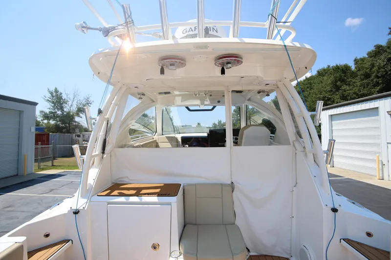  Yacht Photos Pics 2021 Pursuit OS 325 Offshore boat interior with seating and storage, docked outdoors.