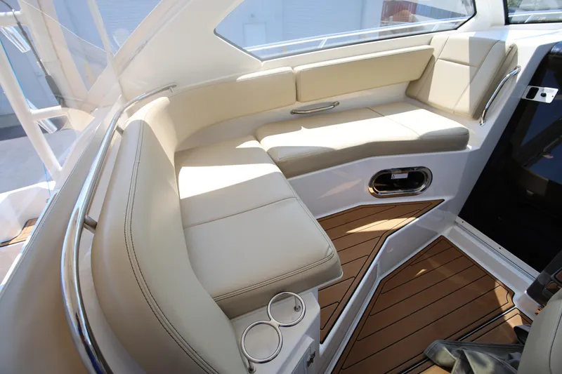  Yacht Photos Pics Luxurious seating area on 2021 Pursuit OS 325 Offshore boat with beige cushions and wood flooring.