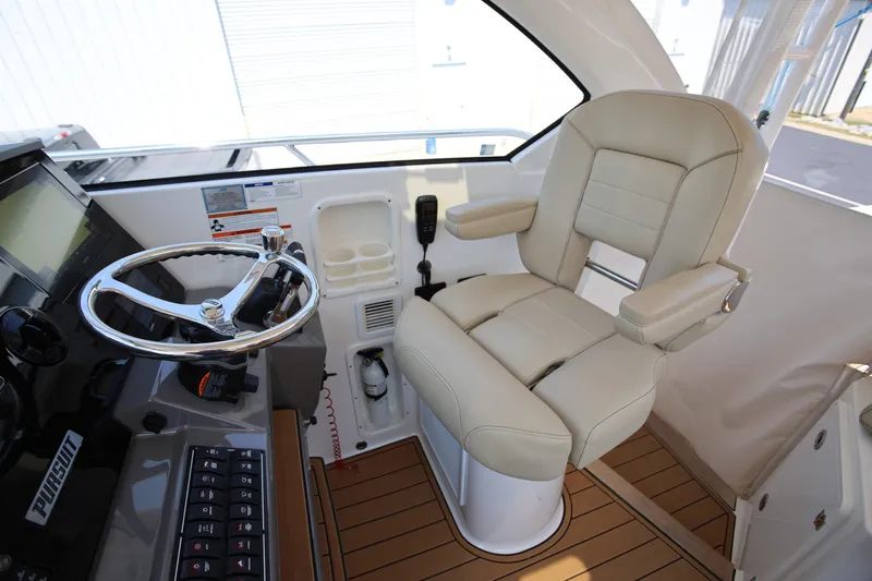  Yacht Photos Pics 2021 Pursuit OS 325 Offshore helm with beige captain's chair and modern controls.