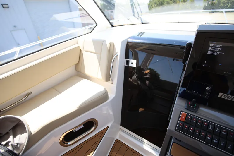  Yacht Photos Pics 2021 Pursuit OS 325 Offshore boat interior with beige seating and modern control panel.