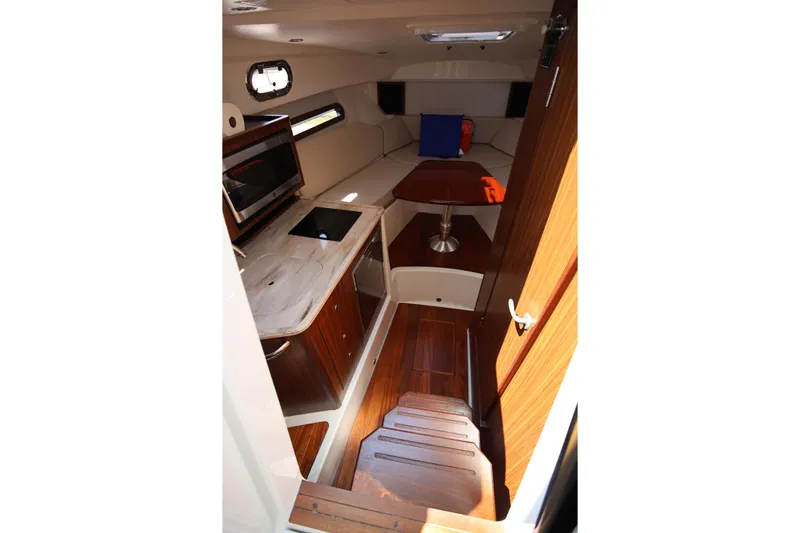  Yacht Photos Pics Interior of 2021 Pursuit OS 325 Offshore boat, featuring a compact kitchen and seating area.