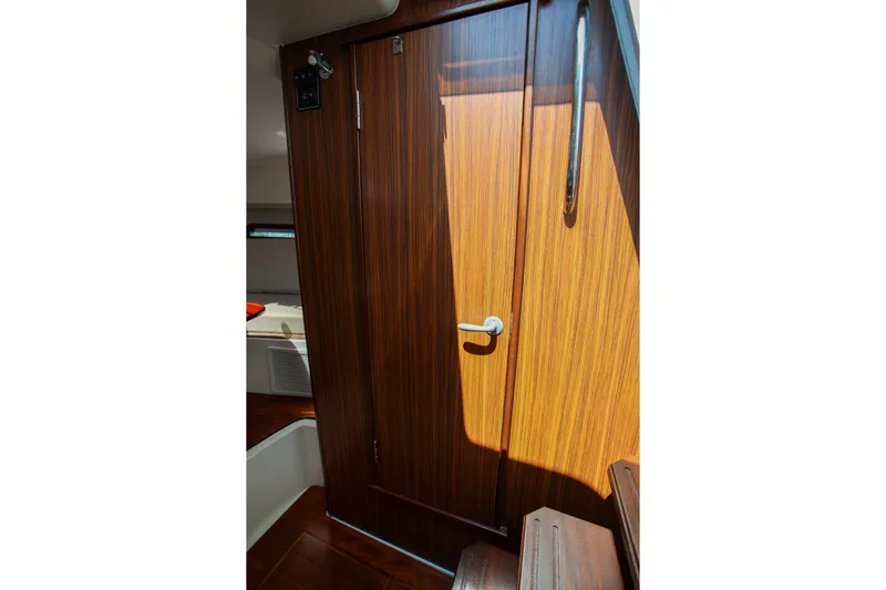  Yacht Photos Pics Interior cabin door of 2021 Pursuit OS 325 Offshore boat, featuring wood finish.