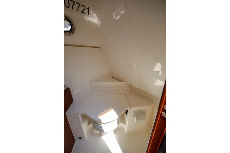  Yacht Photos Pics 2021 Pursuit OS 325 Offshore boat interior with compact marine toilet.