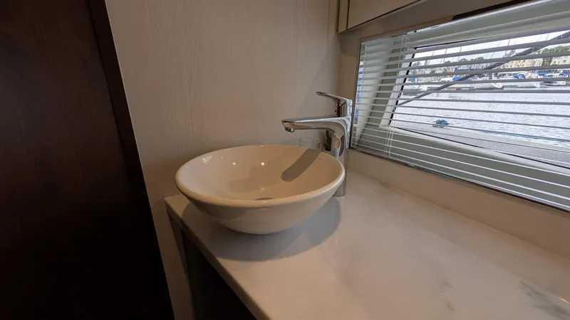 In Stock Yacht Photos Pics Modern bathroom sink in 2025 Fairline Targa 45 GT yacht, with marina view through window blinds.
