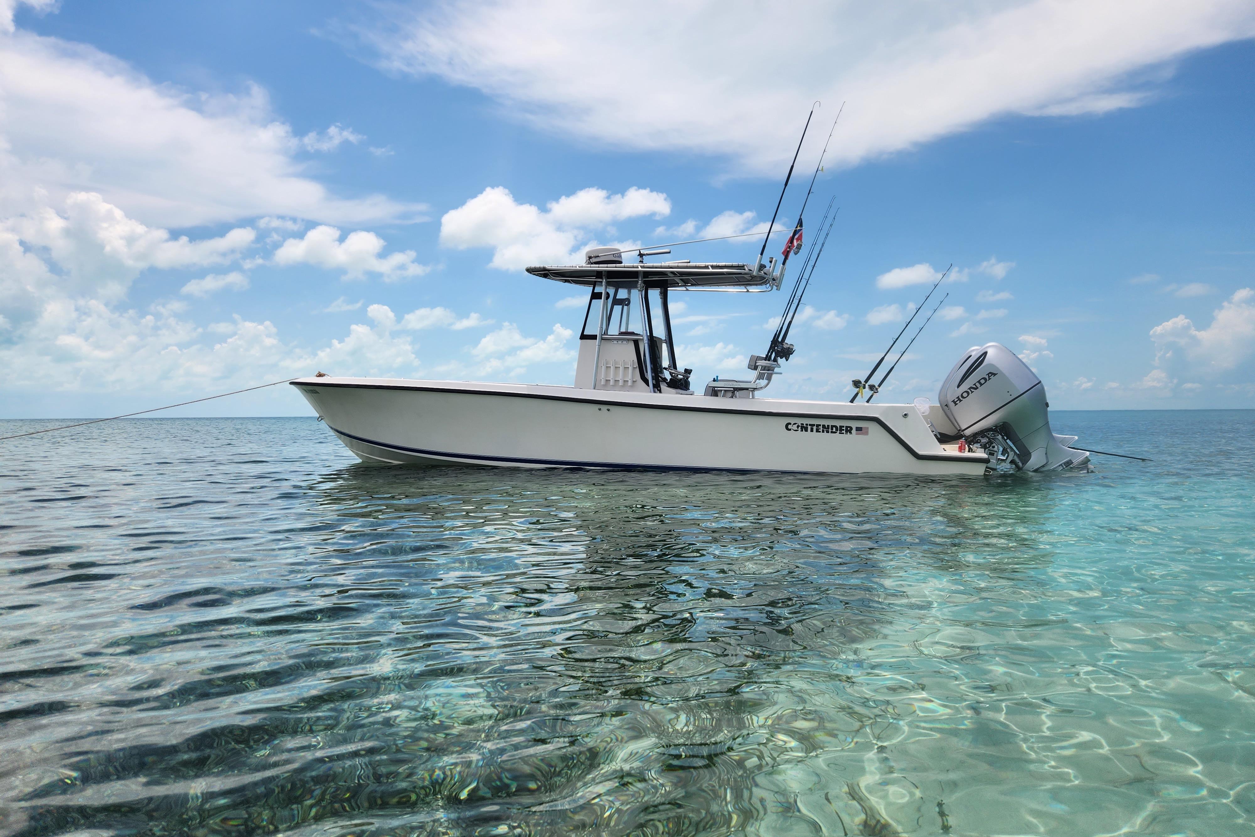 2005 Contender 27 Open boat anchored in clear ocean waters under a blue sky.