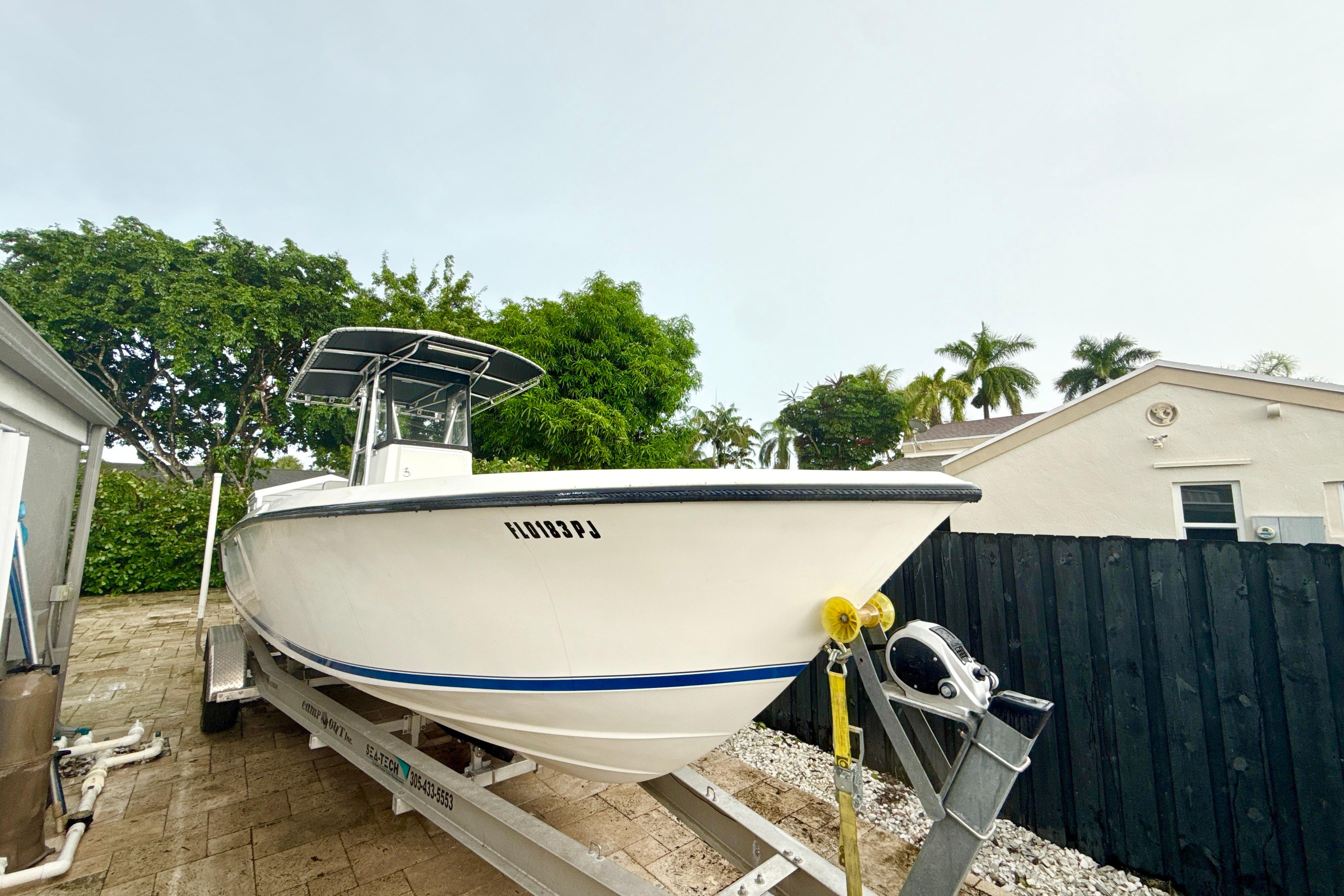 2005 Contender 27 Open boat on trailer, parked outdoors near a house.