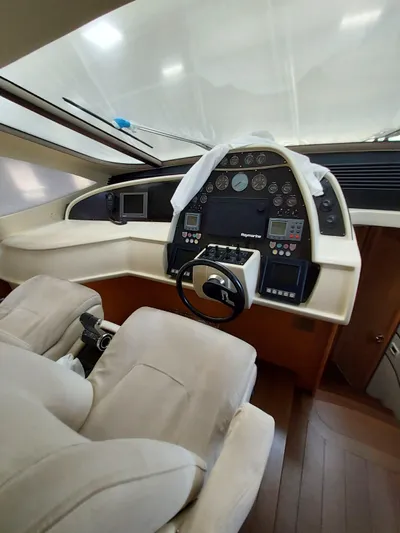  Yacht Photos Pics Interior cockpit of a 2005 Pershing 76 yacht with modern controls and plush seating.