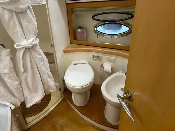  Yacht Photos Pics Bathroom interior of a 2005 Pershing 76 yacht, featuring a toilet, sink, and shower.