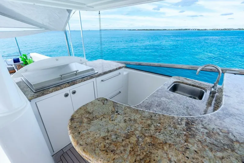 Simplicity Yacht Photos Pics Luxurious Westport 112 yacht kitchen with granite countertops, overlooking serene blue ocean waters.