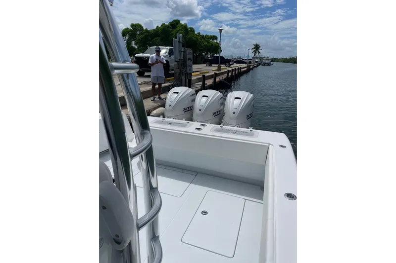  Yacht Photos Pics 2025 Contender 44 ST boat with powerful outboard engines docked by the water.