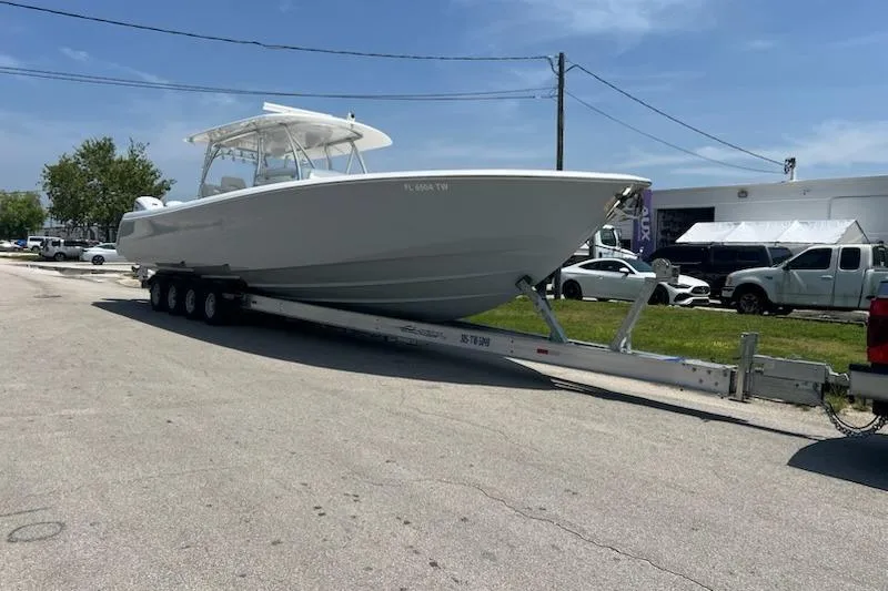  Yacht Photos Pics 2025 Contender 44 ST boat on trailer, parked outdoors under clear sky.