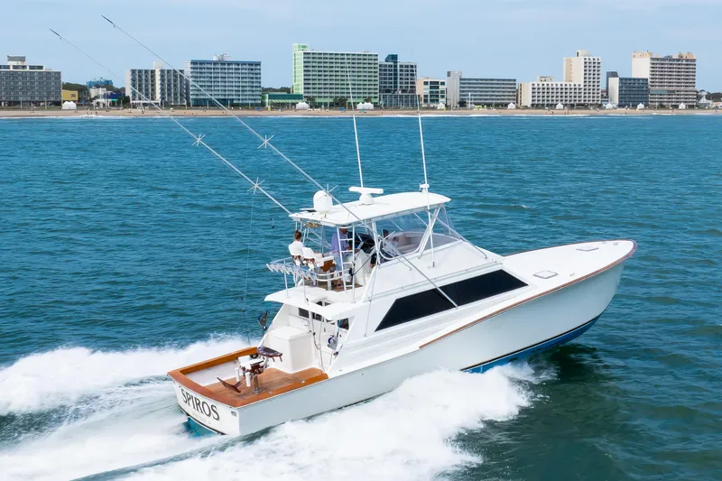 Spiros Yacht Photos Pics 1972 Jim Smith Custom Convertible yacht cruising near a city shoreline.