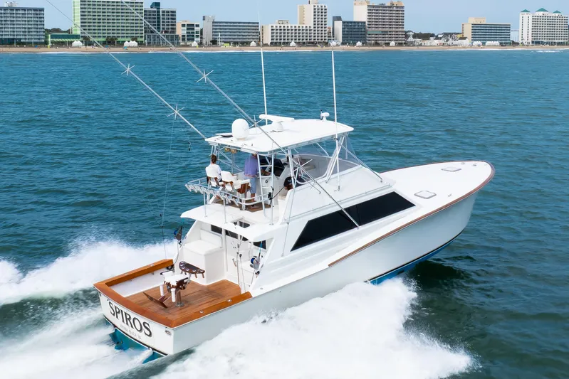 Spiros Yacht Photos Pics 1972 Jim Smith Custom Convertible yacht cruising near a city shoreline.