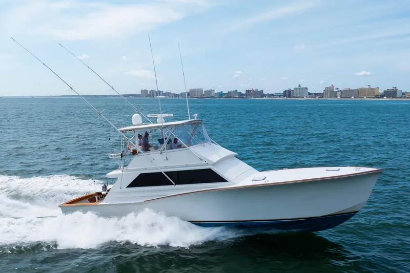 Spiros Yacht Photos Pics 1972 Jim Smith Custom Convertible yacht cruising on ocean near city skyline.