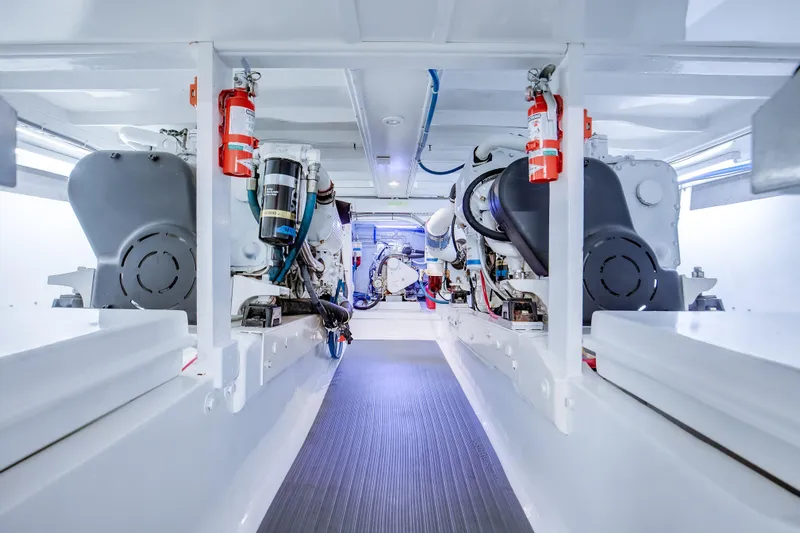 Spiros Yacht Photos Pics Engine room of a 1972 Jim Smith Custom Convertible boat, featuring modern equipment and fire extinguishers.