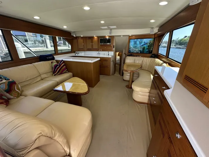 Off Season Yacht Photos Pics Luxurious interior of 2006 Cabo 48 Convertible yacht with leather seating and wooden cabinetry.