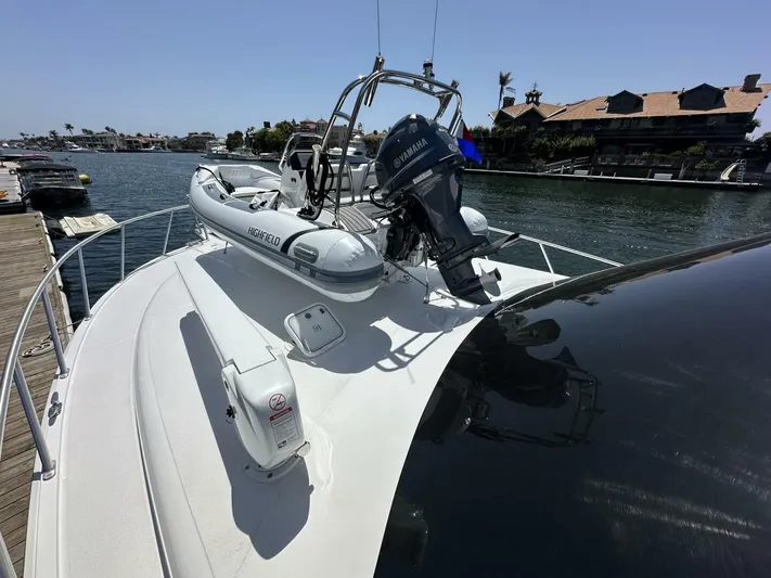 Off Season Yacht Photos Pics 2006 Cabo 48 Convertible yacht with inflatable boat and Yamaha motor on deck.
