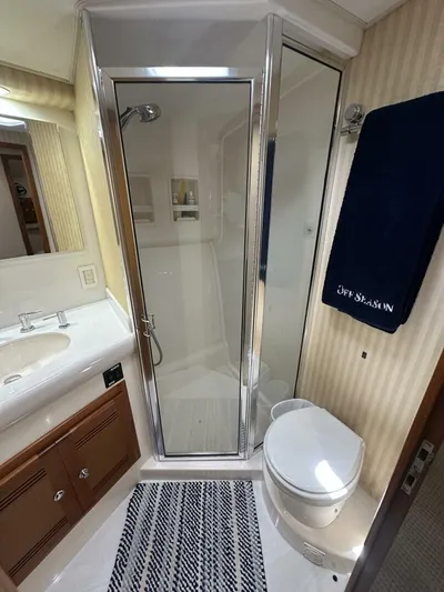 Off Season Yacht Photos Pics Luxurious bathroom in 2006 Cabo 48 Convertible yacht with shower, sink, and toilet.